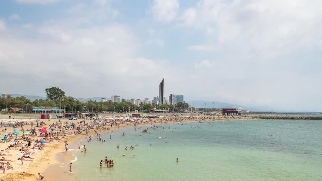 timelapse of a busy beach in the Port Olympic area of Barcelona