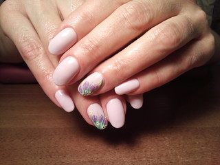The manicurist excellently made her work a beautiful manicure with a polish gel on her hands and the client is happy