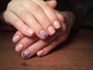 The manicurist excellently made her work a beautiful manicure with a polish gel on her hands and the client is happy