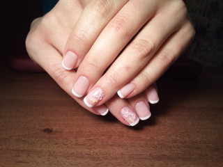 The manicurist excellently made her work a beautiful manicure with a polish gel on her hands and the client is happy