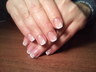 The manicurist excellently made her work a beautiful manicure with a polish gel on her hands and the client is happy