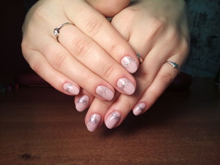 The manicurist excellently made her work a beautiful manicure with a polish gel on her hands and the client is happy