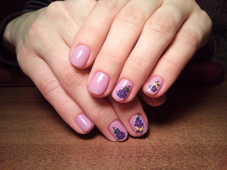 The manicurist excellently made her work a beautiful manicure with a polish gel on her hands and the client is happy