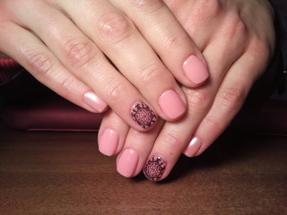 The manicurist excellently made her work a beautiful manicure with a polish gel on her hands and the client is happy