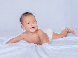 Asian infant lie on the stomach, Do not wear clothes, On a white cloth.