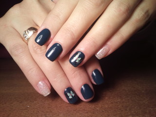 The manicurist excellently made her work a beautiful manicure with a polish gel on her hands and the client is happy