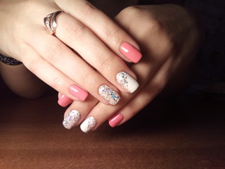 The manicurist excellently made her work a beautiful manicure with a polish gel on her hands and the client is happy