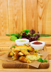 Baked potato with sauce and spices on dark background