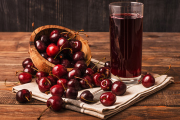 Cold cherry juice in a glass with ripe berries