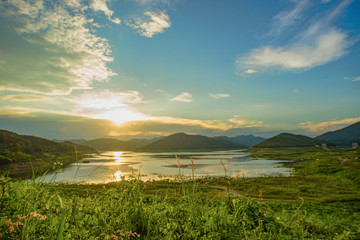 Fototapeta premium Calm River, Mountains, and clouds.