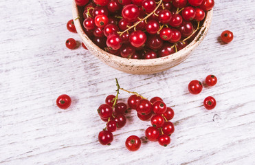 Fresh ripe red currants on rustic wood background.