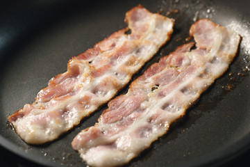 bacon stripes in frying pan closeup