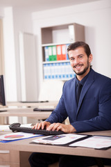 Beautiful Businessman in suit working in his office. Business and corporate. Image of young succesful entrepreneur at his work place.