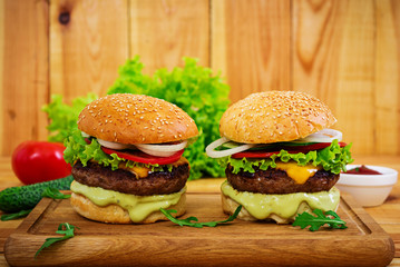 Delicious handmade burger on wooden background. Close view