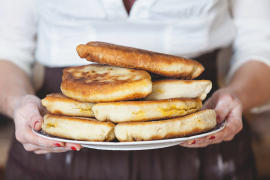 Plate with fried pies in female hands