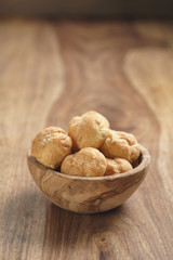 profiteroles in olive bowl on wooden table