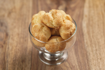 profiteroles in glass bowl on wooden table
