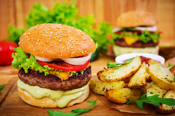 Delicious handmade burger on wooden background. Close view