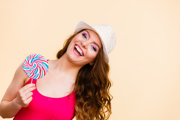 Woman holds colorful lollipop candy in hand