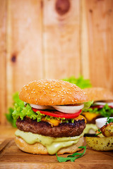 Delicious handmade burger on wooden background. Close view