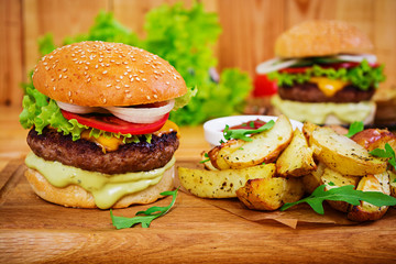 Delicious handmade burger on wooden background. Close view