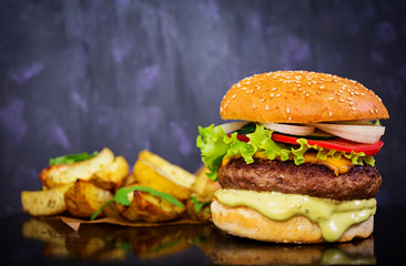 Delicious handmade burger on dark background. Close view