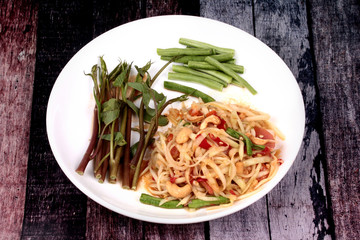 Thai popular recipe, Spicy and sour mixed vegetable salad with papaya roll call Som Tum in Thai topped french fried strick ,lentils and morning glory.