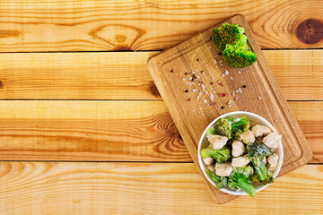 Chicken with broccoli on a wooden background