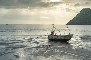 Obraz premium fishing boat on the beach with sea and sunrise background