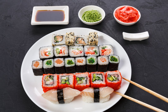Set of sushi and rolls on black background, top view
