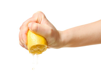 Female hand squeezing half of lemon on white background