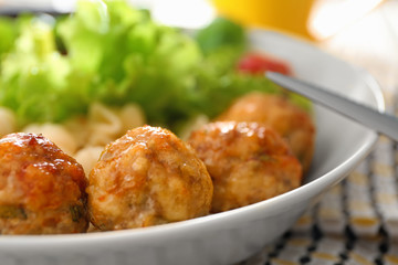 Plate with turkey meatballs and garnish on table, closeup
