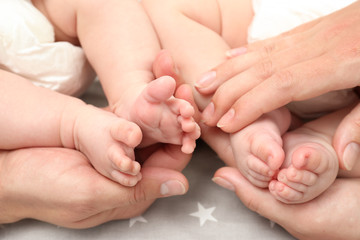 Obraz na płótnie Canvas Parents holding legs of their babies, closeup