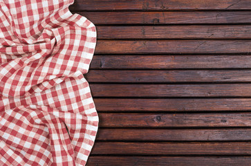 Obraz premium Red checkered tablecloth on dark wooden table with, top view with copy space