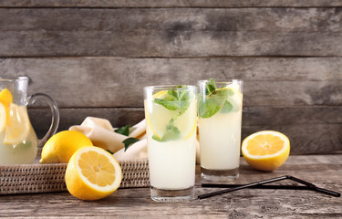 Glasses of fresh lemonade on wooden background
