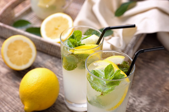 Glasses of fresh lemonade on wooden background