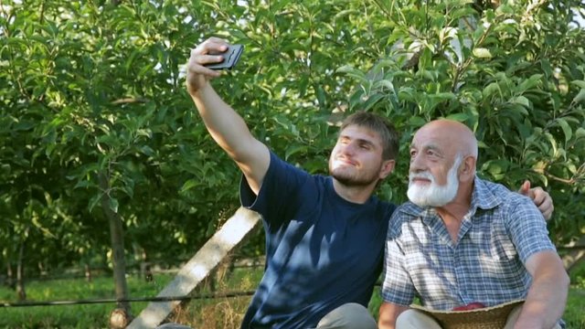 A beautiful grandfather and grandson make selfie smartphone