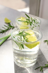 Glasses of fresh lime lemonade with rosemary on table