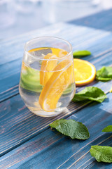 Glass of fresh orange lemonade on wooden table