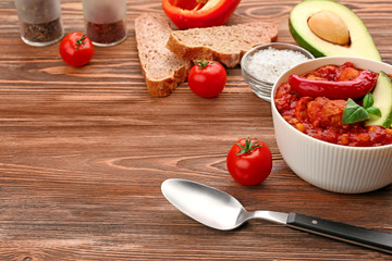 Bowl with delicious chili turkey on wooden background