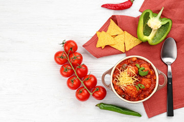 Casserole with delicious chili turkey on wooden table