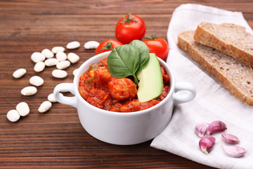 Casserole with delicious chili turkey on wooden table