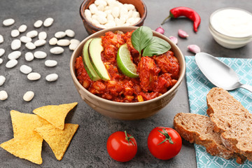 Bowl with delicious chili turkey on table