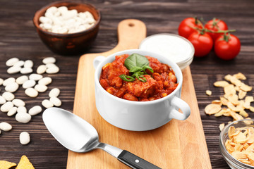 Casserole with delicious chili turkey on wooden board