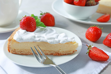 Piece of cake with cream and strawberry on plate