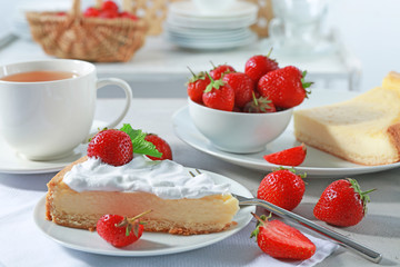 Piece of cake with cream and strawberries on plate