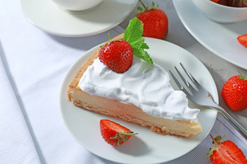Piece of cake with cream and strawberries on plate