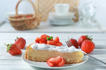 Piece of cake with cream and strawberries on plate