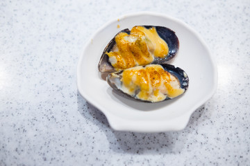 Plate with baked mussels with cheese