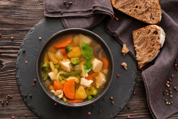 Bowl with delicious turkey soup on slate plate